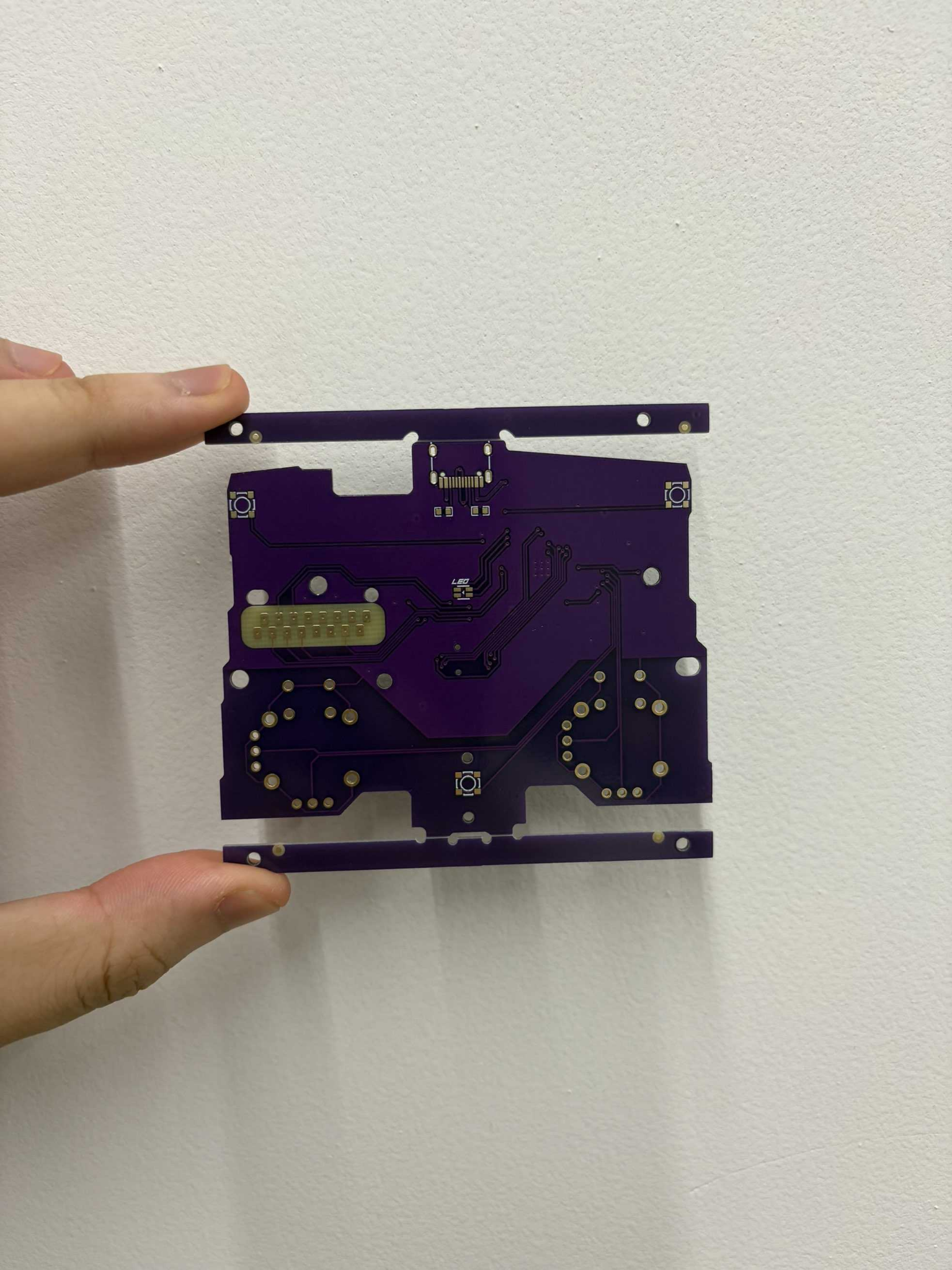 Purple Hyperstrike 8K controller circuit board held in a hand